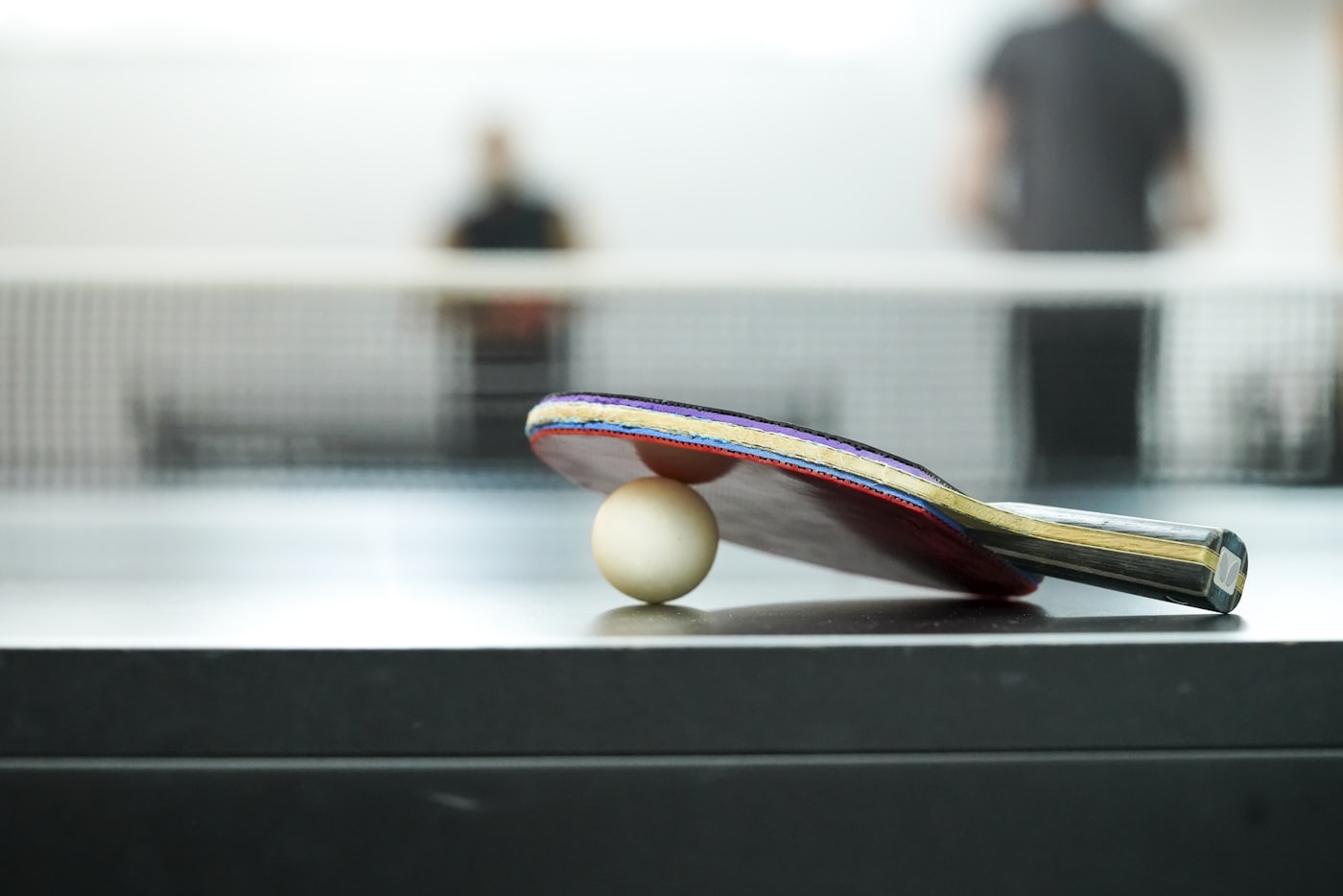Tischtennisschläger und Ball vor dem Netz